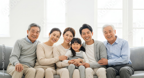 Happy Asian Family Portrait: Three Generations Smiling Together on Sofa