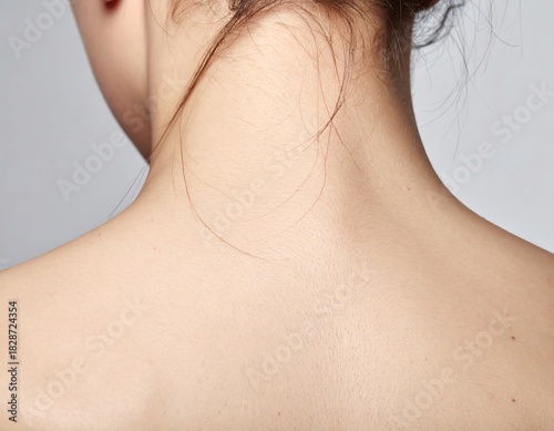 Close-up of a woman's smooth and healthy skin on her back, neck, and shoulders, showcasing