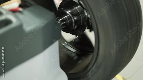 Professional auto mechanic changing and balancing car wheel in a tire fitting workshop