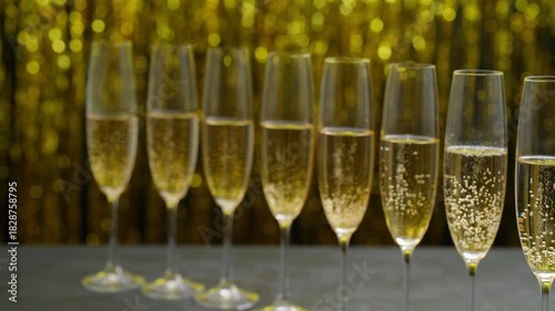 Many glasses of champagne in a line. Row of champagne glasses filled. Lot of glasses filled with champagne are lined up.