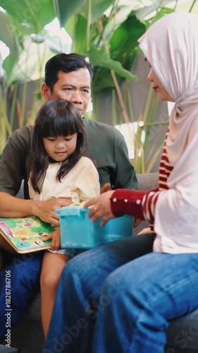 Muslim family reading a children's book together at home