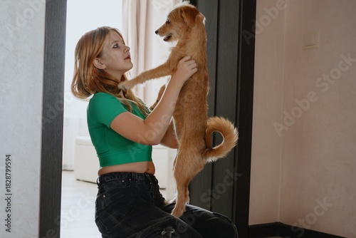 A 12-year-old teenage girl plays and laughs joyfully with her dog. Authentic moment of teen-pet bonding, pure happiness and carefree friendship