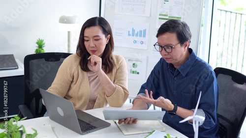 Asian business adults collaborate on sustainable energy project strategy office meeting analyze data renewable solutions global impact discussion corporate success