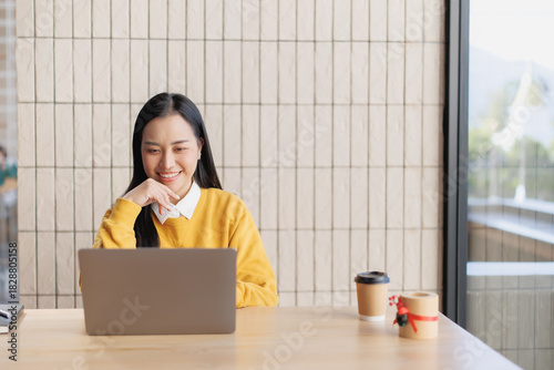Woman smiling and working on laptop in cafe