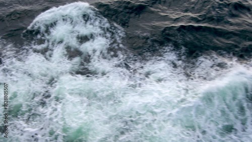 Dynamic northern rough ocean waves with choppy water and white sea foam captured from a ship, showcasing powerful dark sea motion. Perfect for travel, nature, and dramatic maritime video backgrounds