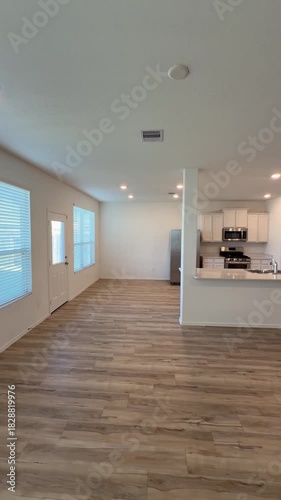 Empty House Interior Open Concept Living Room and Kitchen with Wood Flooring.  