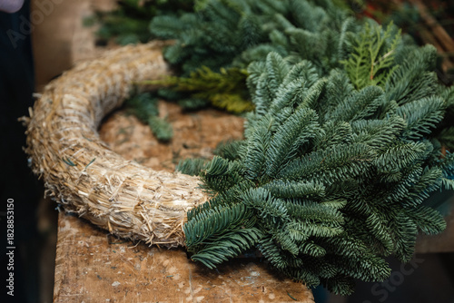 Unfertiger Adventskranz aus Stroh und frischen Tannenzweigen