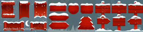Collection of red christmas themed banners and signs with snow on top in a wintery scene