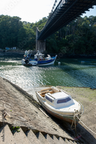 A small boat is tied to a pier