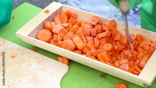 Chopping carrots in a wooden trough