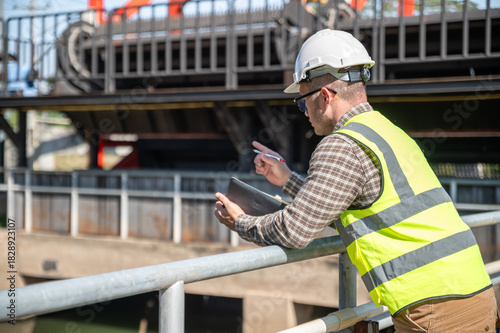 Field engineer taking notes during an outdoor inspection of the industrial water management facility