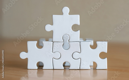 A closeup view of interlocking white jigsaw puzzle pieces forming a structure, highlighting the concept of building, integration, and finding the right fit