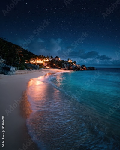 Warm Resort Lights Reflecting on Serene Tropical Beach at Night with Turquoise Ocean.