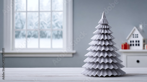 White origami Christmas tree decorating a minimalist home interior, showing snowy window view and holiday season