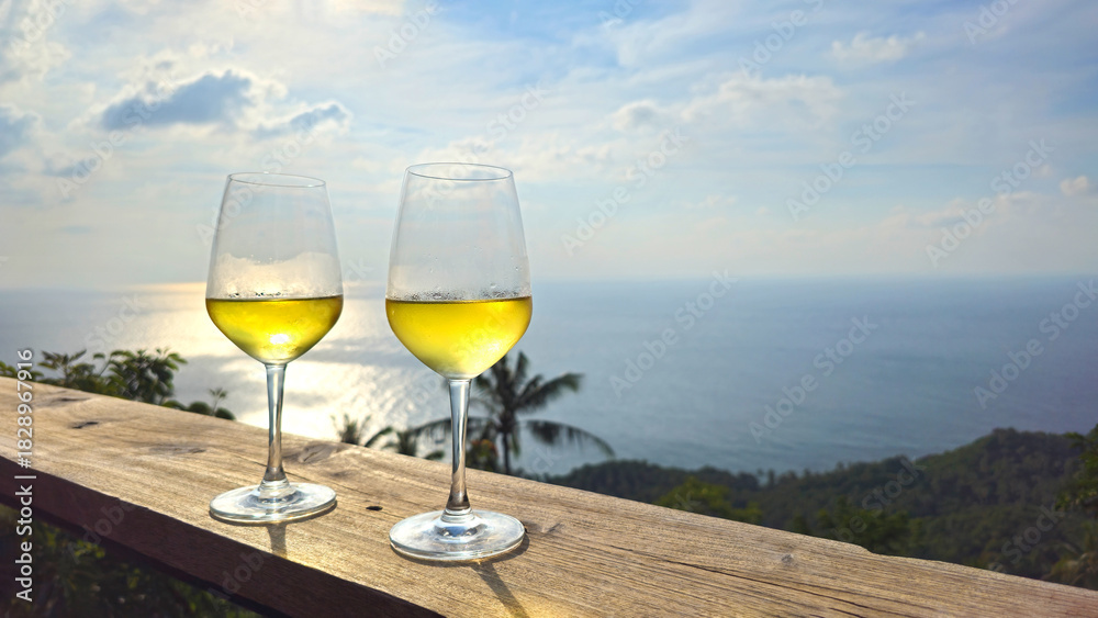 Obraz premium Two glasses of white wine ocean view at sunset, Island Ko Tao, Surat Thani, Thailand, Southeast Asia.