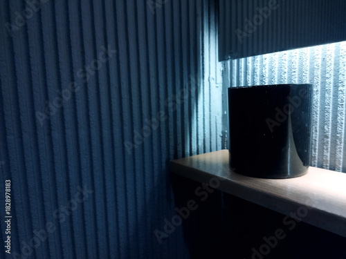 Modern decor featuring a sleek black object on a wooden shelf