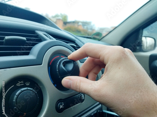 Adjusting the car's climate control for comfort on a cool day