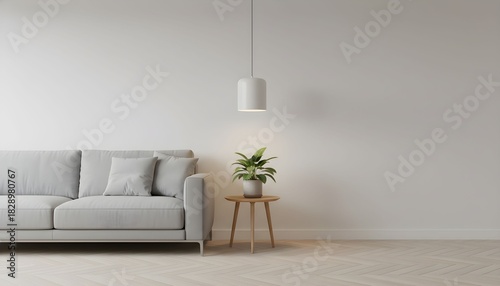 Minimalist living room with gray sofa, wooden table, plant, and pendant light against a white wall.