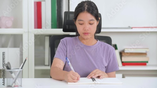 A cheerful woman sits at her desk with a laptop, ready to work or study from home