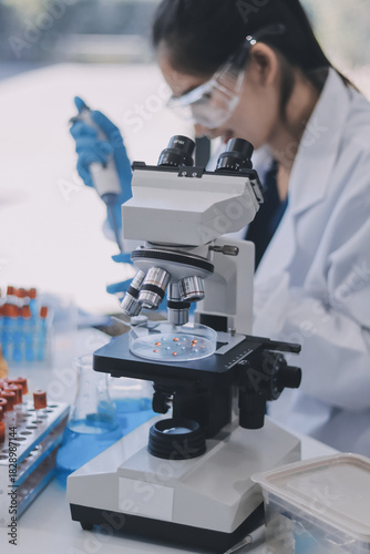 Portrait, science and happy woman on laptop in lab to research chemistry, test or innovation. Microscope, scientist and face of medical doctor in goggles for microbiology, healthcare or pharma study