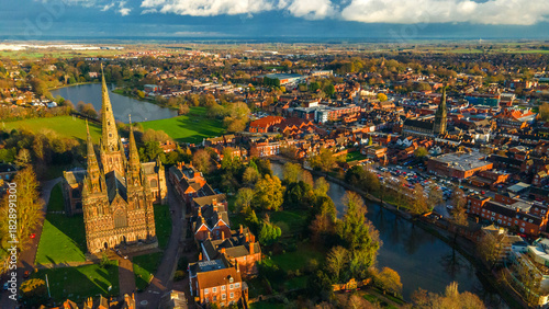 Lichfield Cathedral beside wide urban lake and green waterfront area