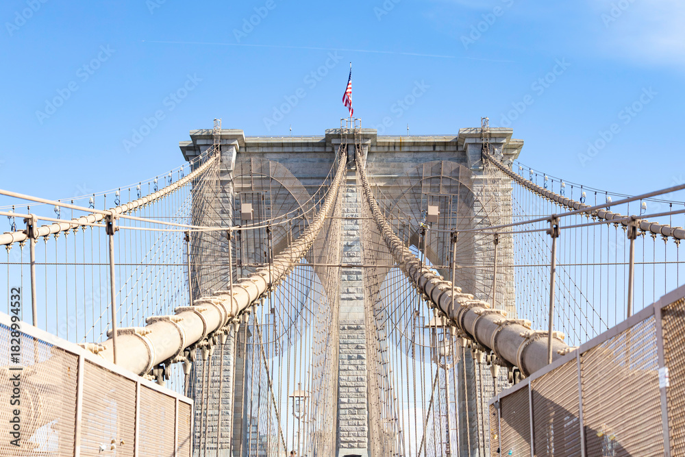 Obraz premium The pedestrian section of the Brooklyn Bridge in New York City is empty of people during the day.