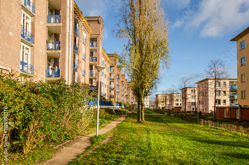 Amsterdam, The Netherlands, November 25, 2025: residential buildings with brick and plaster facades and a green strip in between