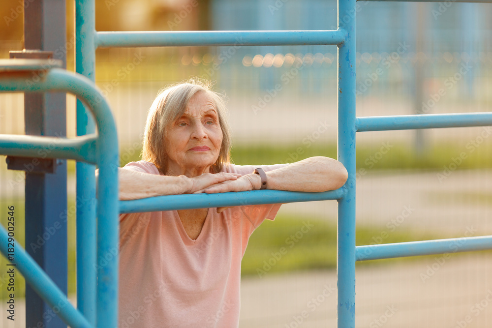 Obraz premium Serious Senior Woman Resting at Outdoor Gym. Healthy Life Concept.