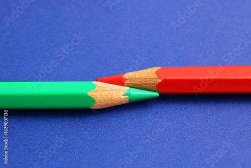 A green pencil next to a red pencil, complementary colors