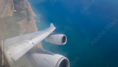 Wallpaper Mural Airbus A340 flight shortly after takeoff from Barcelona's El Prat Airport, and a view of the seashore from the plane window Torontodigital.ca