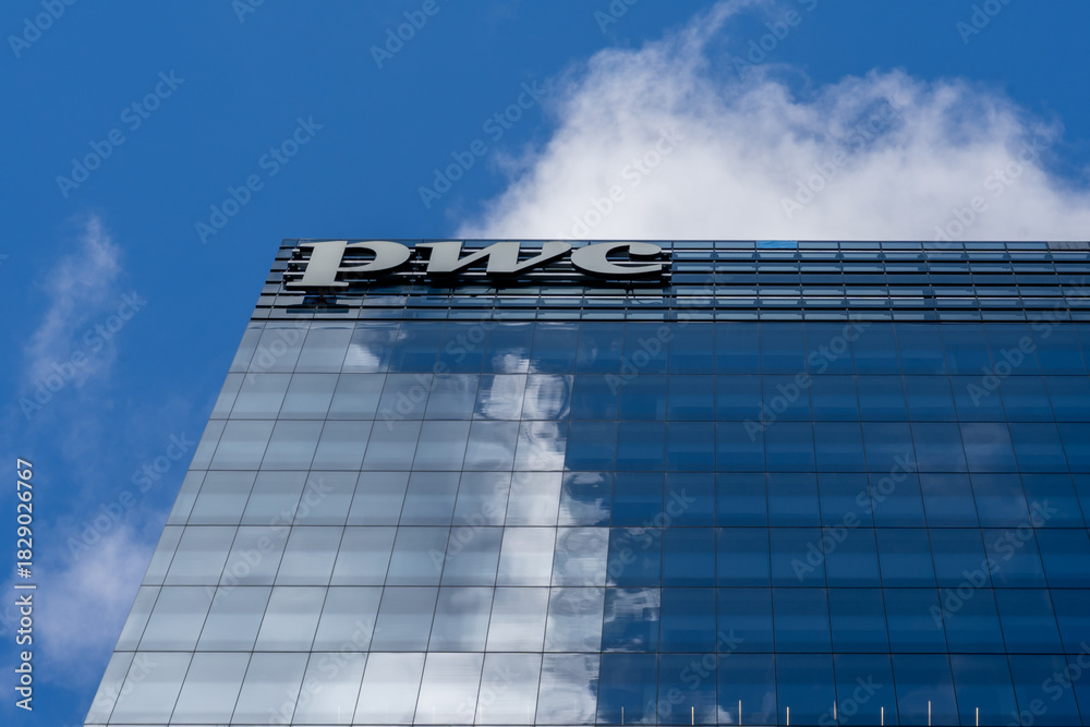 Fototapeta premium Toronto, Canada - September 21, 2025: Close up of PWC sign on the building. Toronto, Canada. PwC (PricewaterhouseCoopers) is a multinational professional services network of firms.