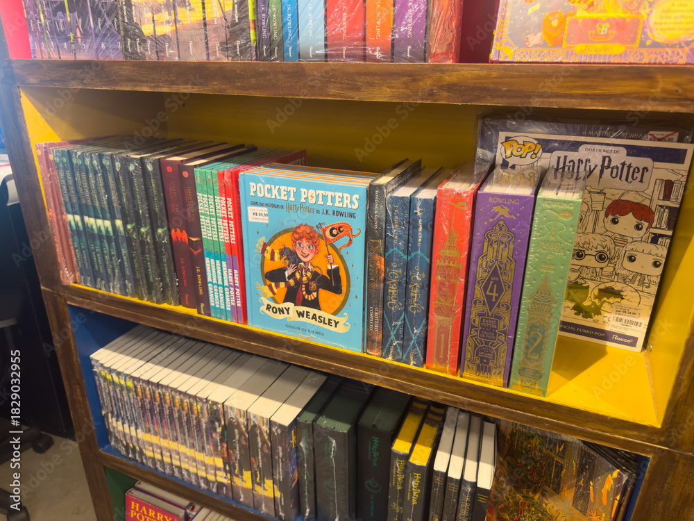 Fototapeta premium BELO HORIZONTE, MG, BRAZIL – NOVEMBER, 26, 2025: Display of Harry Potter books, including 'Pocket Potters' and Funko Pop items, on store shelves.