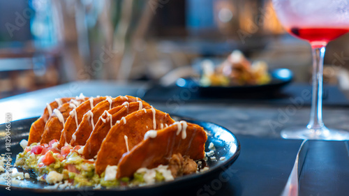 Enchiladas potosinas servidas con guacamole y crema en restaurante mexicano