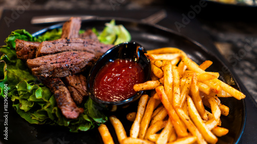 Carne asada servida con papas fritas y salsa en restaurante nocturno