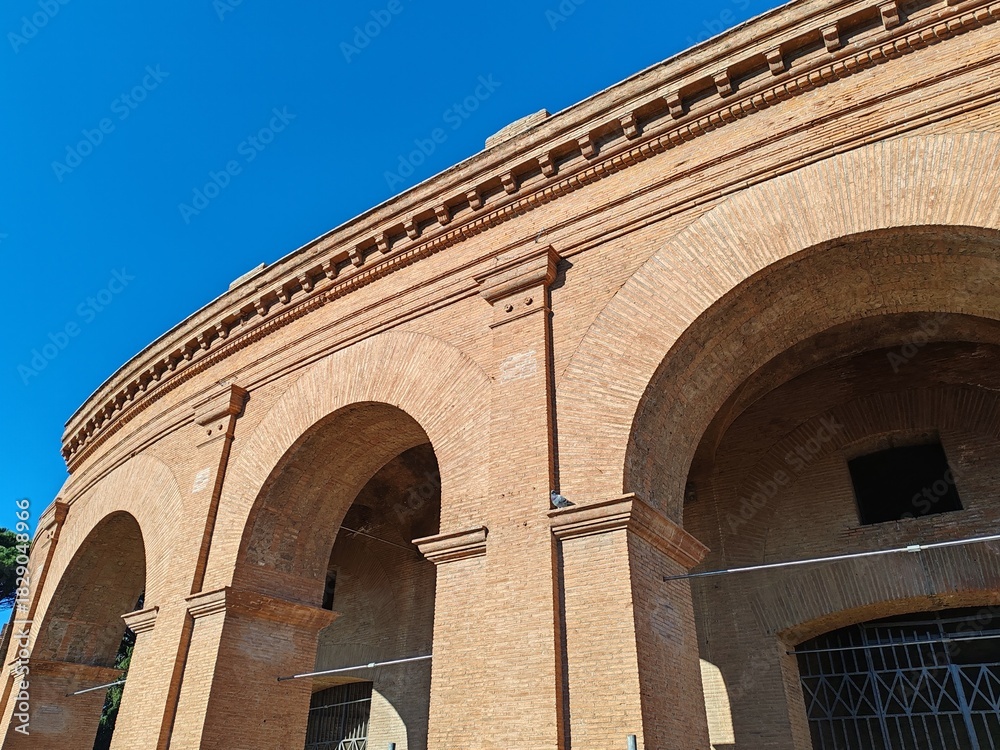 Fototapeta premium Ostia Antica, Rome, Italy - November 23, 2025, detail of the arches and perimeter brick wall of an entrance to the Roman theater in Ostia.