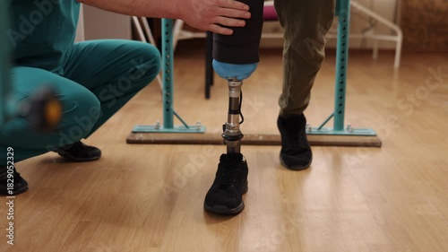 physical therapy, rehabilitation center, organized space. Man with prosthetic leg receives physical therapy from medical expert, using parallel bars to help him walk in rehabilitation facility