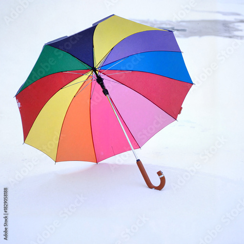 Colorful umbrella standing in the snow, creating a vibrant contrast in a winter landscape