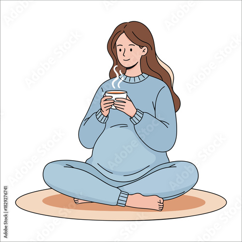 Pregnant woman sitting cross-legged holding a steaming cup of tea lotus position