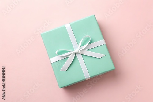  gift box with a delicate white ribbon on a soft pink background