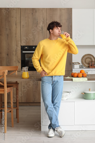 Young man drinking orange j...