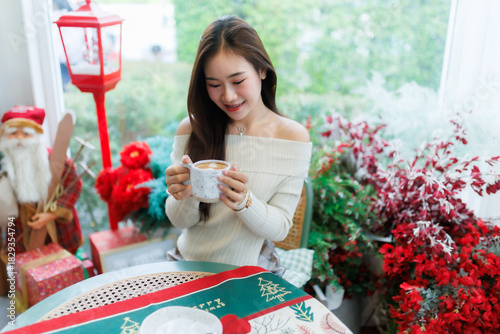 Portrait beautiful asian woman holding of positive the having cup of coffee,milk or chocolate at home in the living room indoors Decoration During Christmas x-mas and New Year holidays.