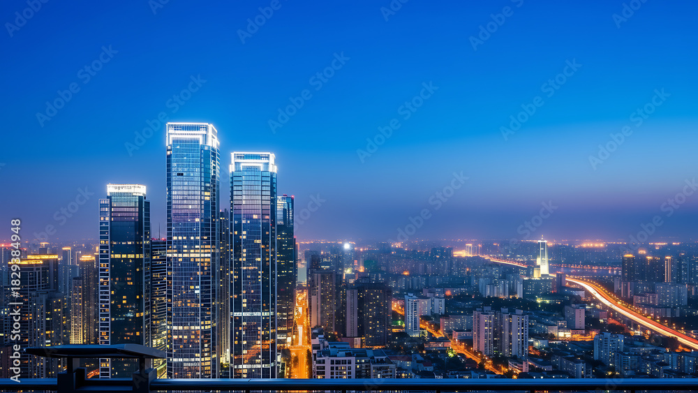 Fototapeta premium Cityscape view at night featuring illuminated skyscrapers and vibrant urban lights under a blue sky