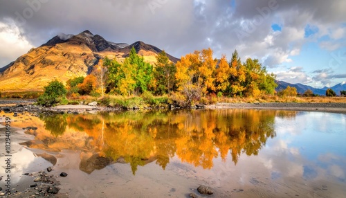 Scenic Autumn Landscape with Mountain Reflection in Calm Water and Cloudy Skies