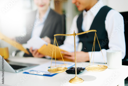 Business and lawyers discussing contract papers with brass scale on desk in office. Law, legal services, advice, justice and law concept . in office