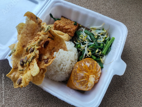 Nasi pecel and sego pecel are typical Javanese Indonesian rice dishes served with pecel sauce, vegetables and others.	