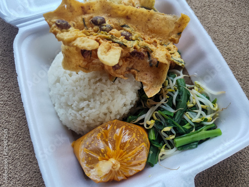 Nasi pecel and sego pecel are typical Javanese Indonesian rice dishes served with pecel sauce, vegetables and others.	