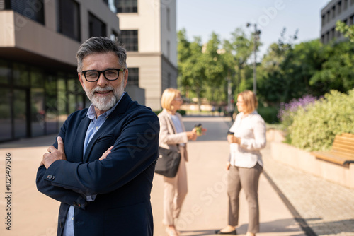 Mature urban business man with specs crossing his arms