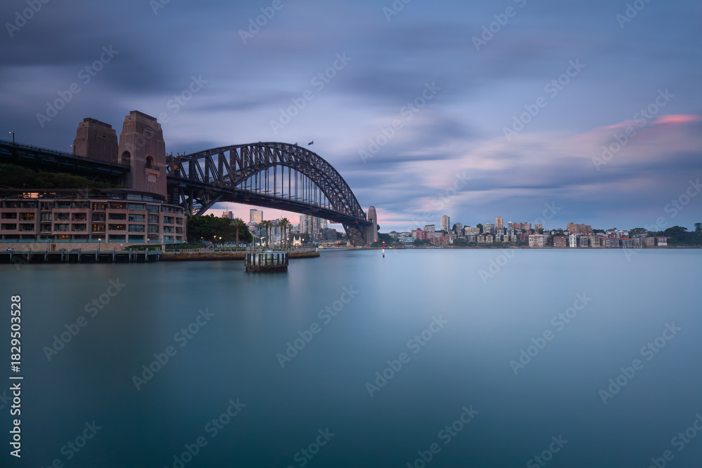 Naklejka premium Die Sydney Harbour Bridge und Kirribilli in der späten Dämmerung. Sanfte Übergangszeit: Langzeitaufnahme des beleuchteten Hafens.