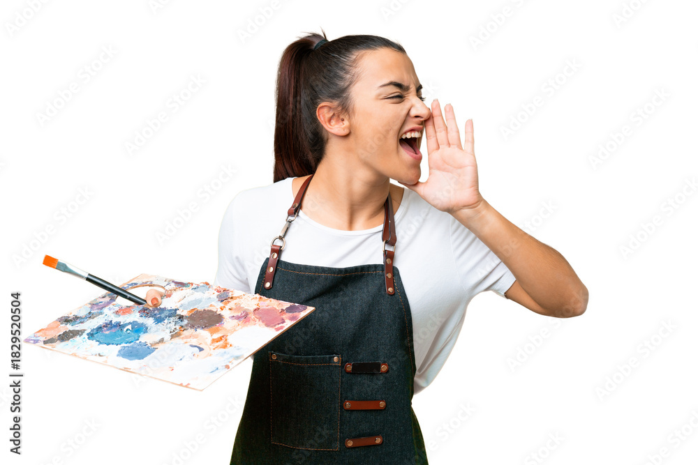 Obraz premium Young artist woman holding a palette over isolated chroma key background shouting with mouth wide open to the side