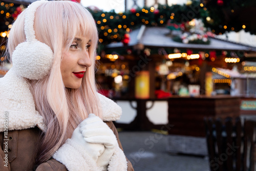Woman wearing headphones at a Christmas market. Space for writing text